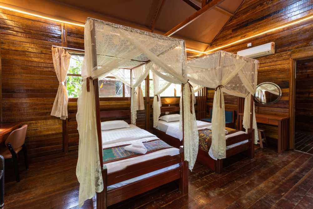 Twin chalet room with two single beds under mosquito nets